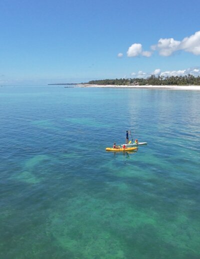Kayakers paddling on calm turquoise waters off Almanara Resort in Diani.